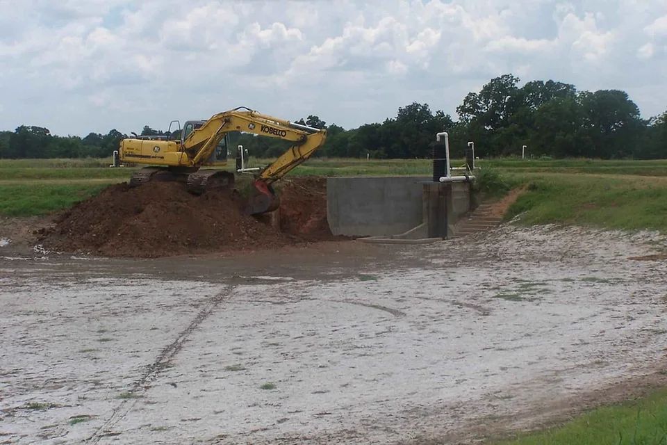 Tracked excavator moving soil at an excavation site