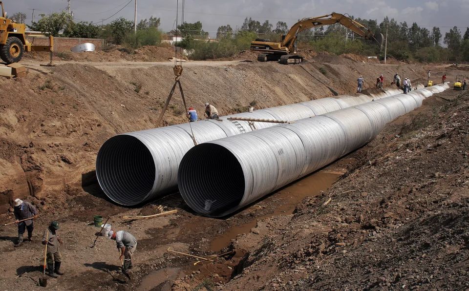 Large storm-drain pipe being installed in a trench in Guasave, Mexico