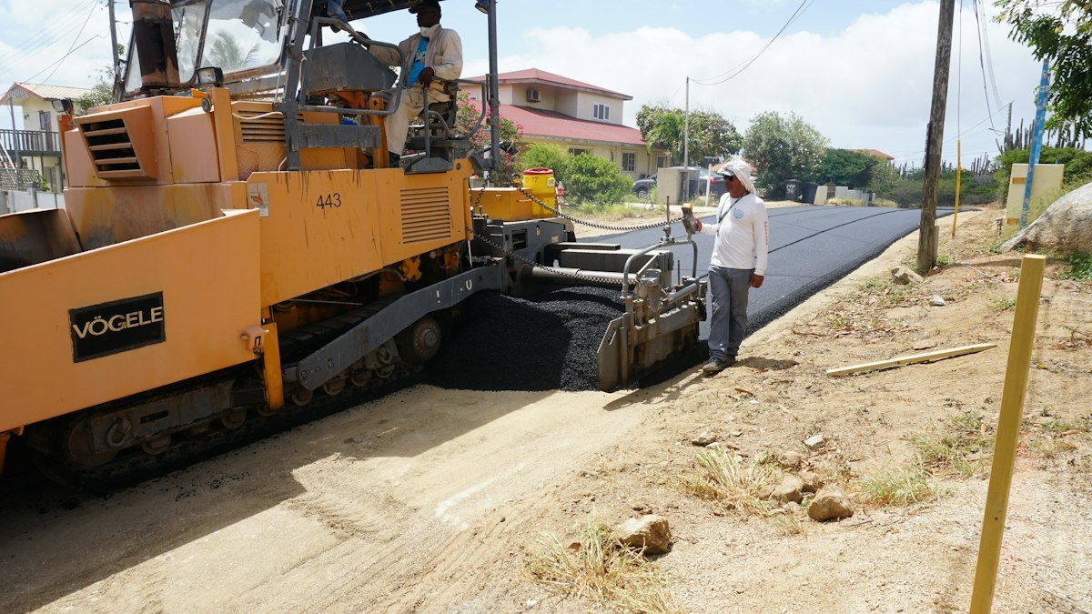 Road crew and paving machinery laying asphalt on a street