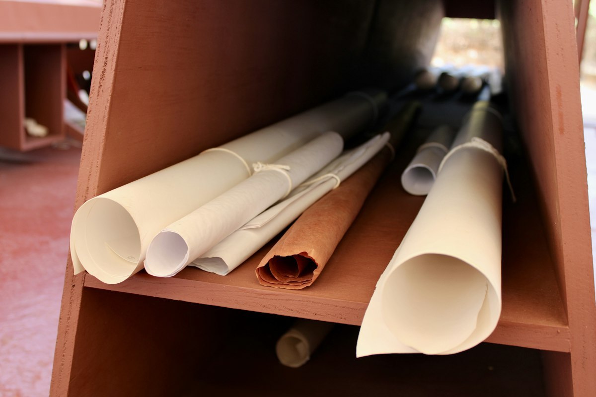 Rolled architectural plans and drawing tubes arranged on shelves at Taliesin West