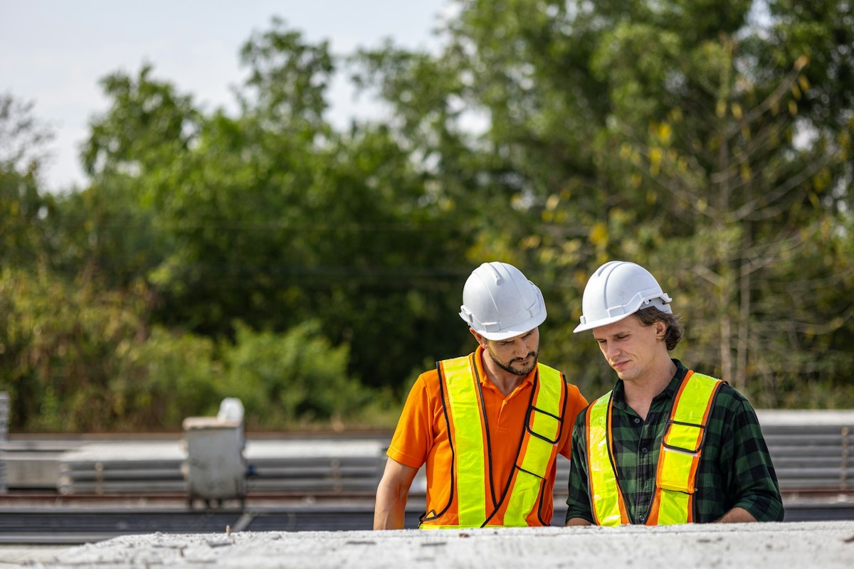 Two engineers checking plans in a concrete production factory
