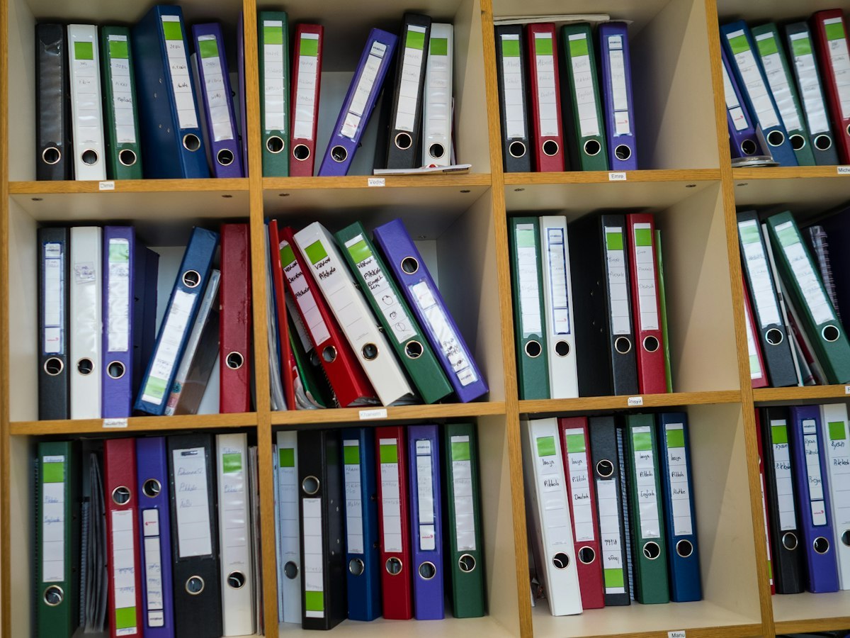 Labelled folders and reference binders stored on office shelves