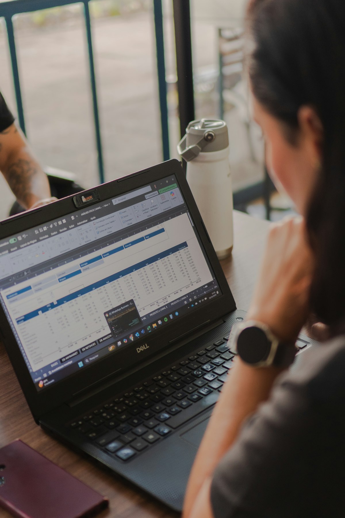 A woman reviewing spreadsheet data on a laptop