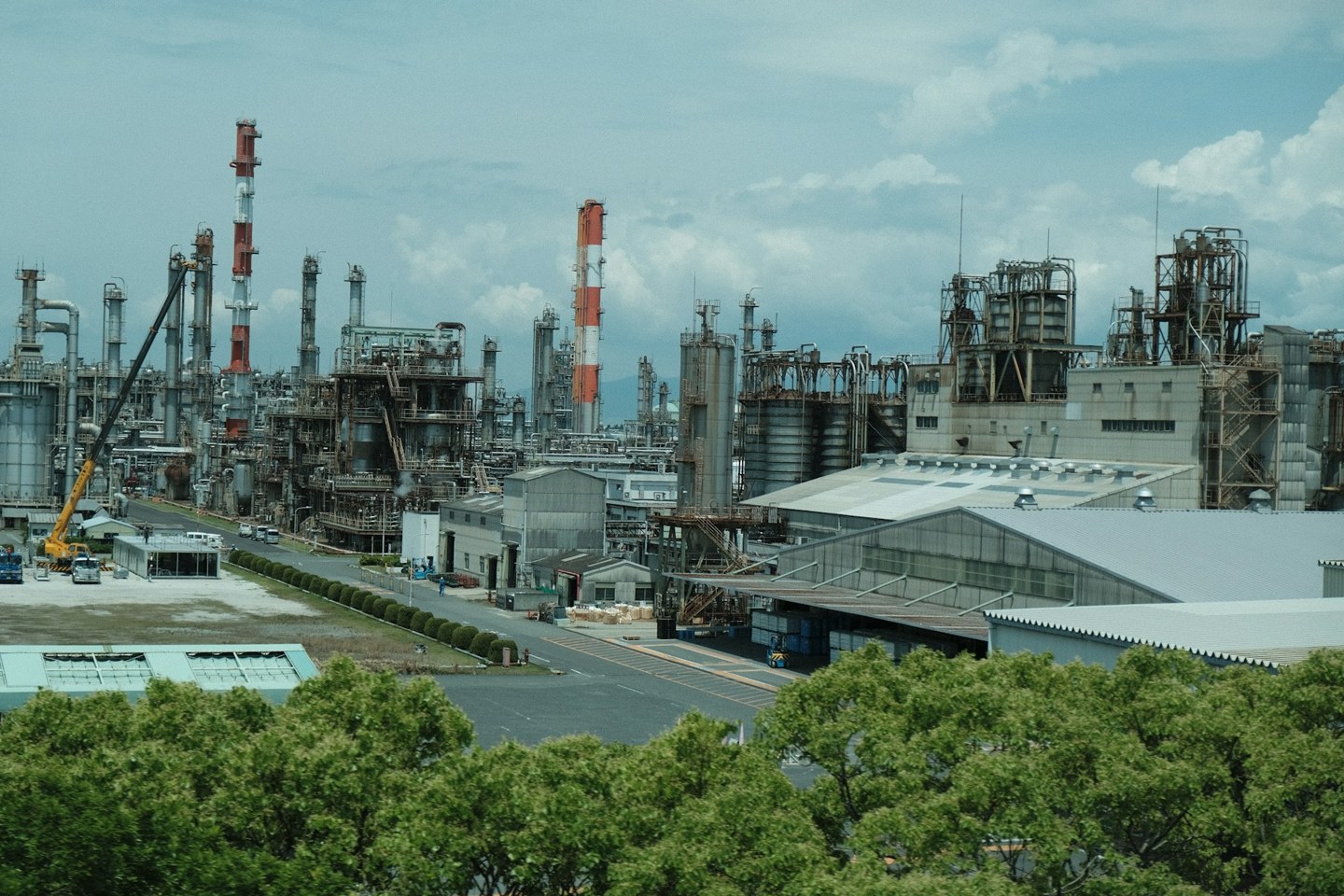 Wide view of a process-engineering plant with towers, pipework, tanks and industrial buildings