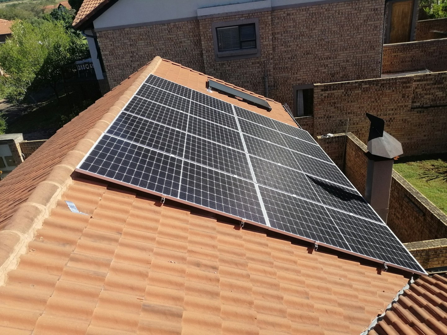 Photovoltaic panels installed across a tiled residential roof