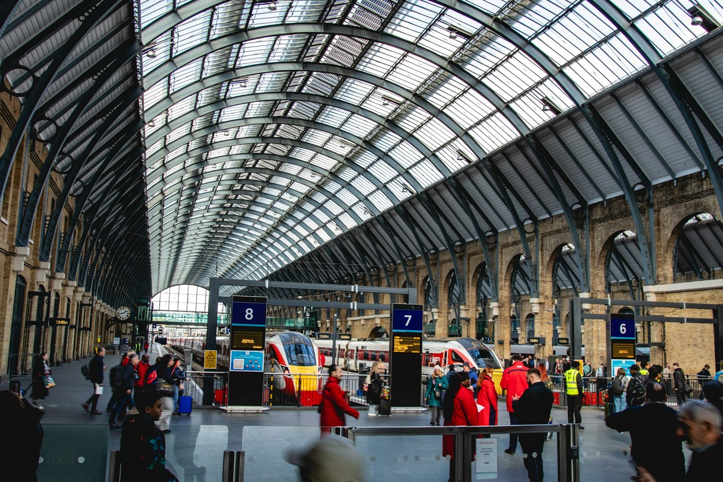 Trains and platforms beneath the glass and steel roof of King's Cross station in London