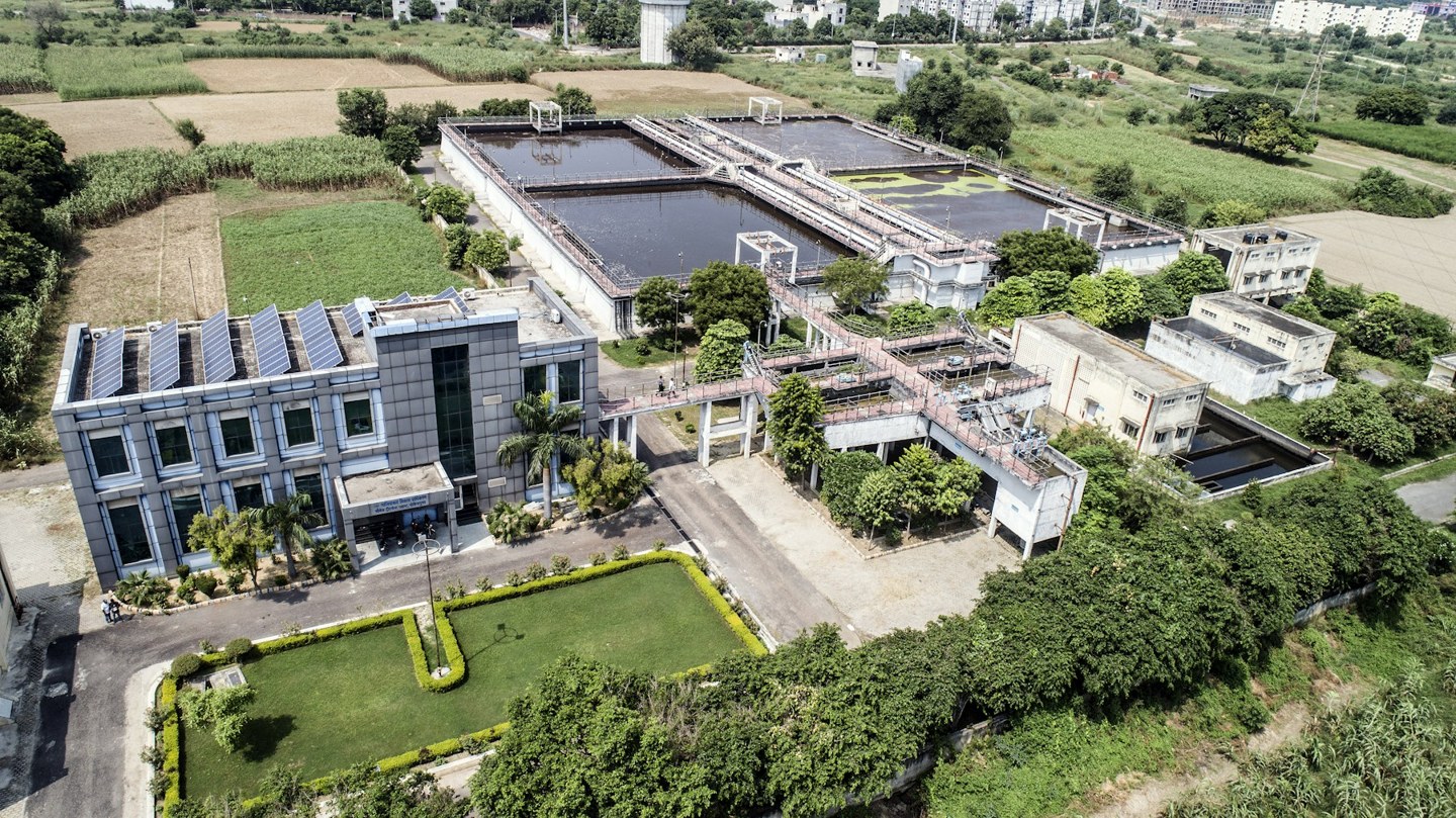 Aerial view of a sewage-treatment plant with rectangular process basins and associated buildings