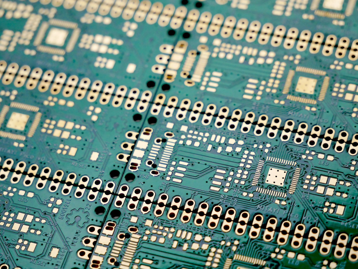 Unassembled printed circuit boards with gold-coloured contacts and fine conductive traces